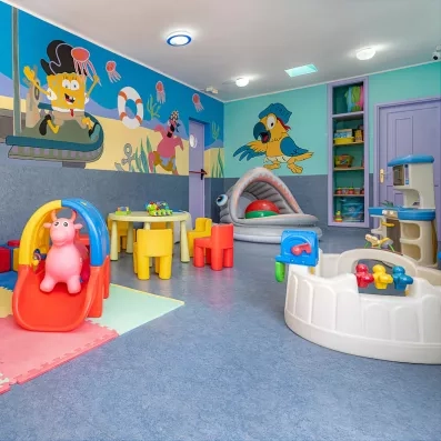 Une aire de jeux intérieure ludique comprenant un petit toboggan, une piscine à balles.