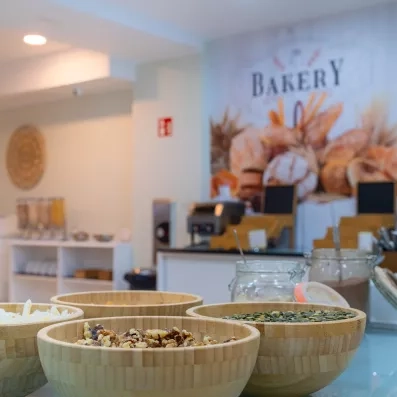 Une vue de larges paniers d'osier remplis de produits devant un espace de restauration lumineux.