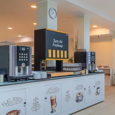 Une station de boissons en libre-service équipée de machines à café et de jus de fruits.