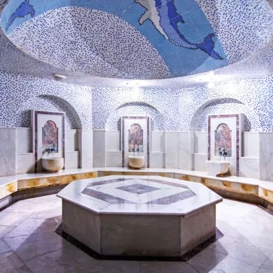 Un hammam traditionnel en marbre blanc doté d'une coupole ornée d'une mosaïque.
