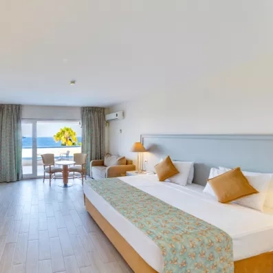 Une vaste chambre disposant d'un grand lit, d'un canapé et d'une vue imprenable sur la mer.