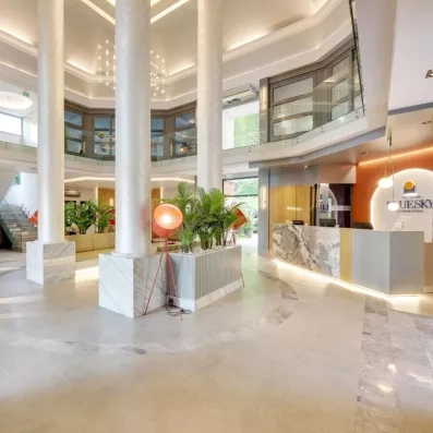 Un hall d'entrée luxueux avec d'immenses colonnes blanches et un sol en marbre.