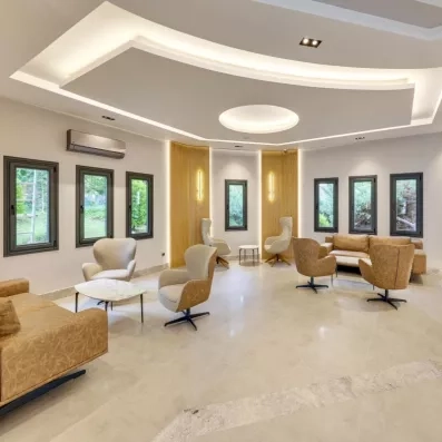 Un salon d'hôtel moderne et lumineux aux tons neutres, avec des fauteuils élégants.