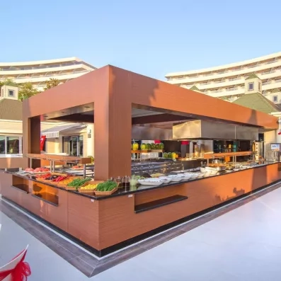 Un large buffet moderne et boisée située en extérieur au cœur du complexe hôtelier.