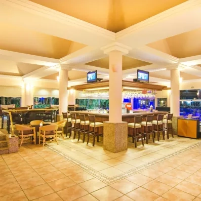 Un bar intérieur élégant et spacieux avec un comptoir central et des tabourets hauts.