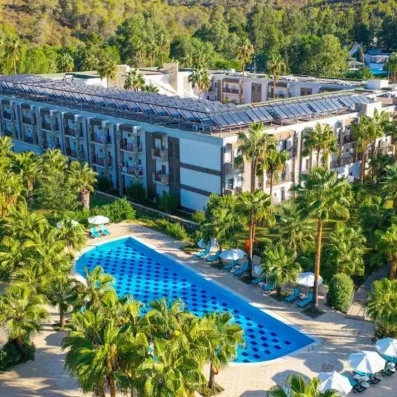 vue de l'hôtel et de la piscine avec des palmiers