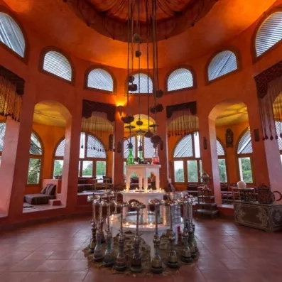 Salle orientale chaleureusement aménagée, dotée de nombreux narguilés, de banquettes décorées