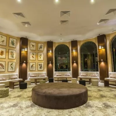 Salon spacieux décoré de panneaux bois, sièges lounge et illustrations murales