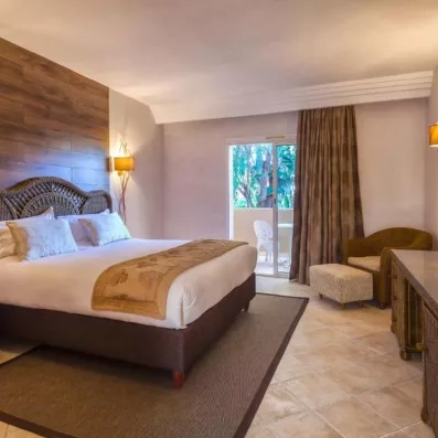 Chambre spacieuse et lumineuse avec grand lit et balcon verdoyant