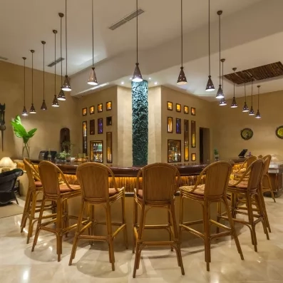 Bar élégant avec comptoir en bois, luminaires suspendus et ambiance chaleureuse