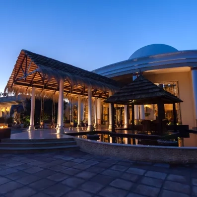 Entrée élégante éclairée, avec structures en bois et ambiance nocturne chaleureuse
