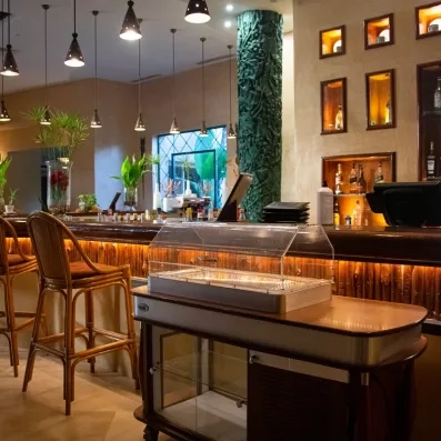 Bar élégant avec éclairage chaleureux, comptoir en bois et vitrines décoratives