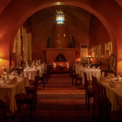 Restaurant intimiste aux tons chauds, éclairé par bougies et lanternes décoratives