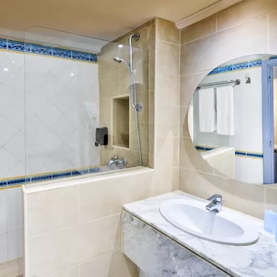 Salle de bain moderne avec vasque en marbre et douche à l'italienne à l'hôtel Les Quatre Saisons Djerba.