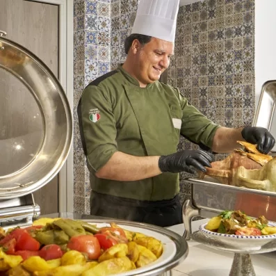 Chef servant une spécialité culinaire traditionnelle tunisienne dans le restaurant de l'hôtel Les Quatre Saisons.