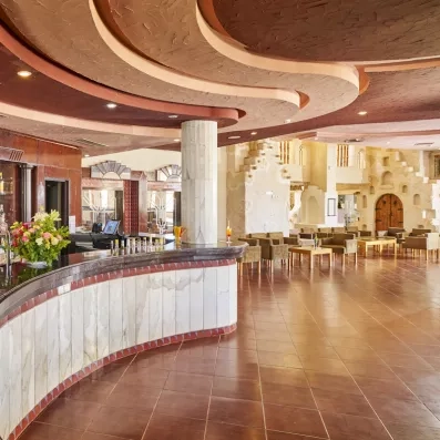 Bar intérieur élégant avec comptoir en marbre et salon confortable au design architectural unique à Djerba.
