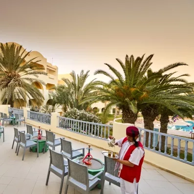 Service de thé à la menthe traditionnel sur une terrasse face aux palmiers à l'hôtel Les Quatre Saisons.