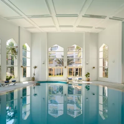 Piscine intérieure chauffée et lumineuse sous une coupole blanche élégante à l'hôtel Marhaba Salem Monastir.