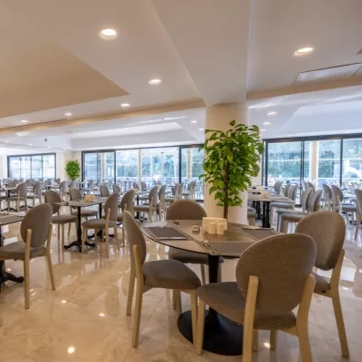 Une salle de restauration avec des chaises grises et une atmosphère aérée.