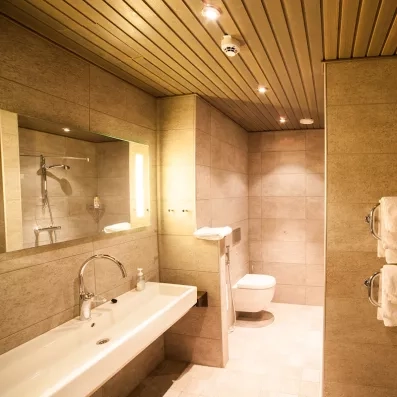 salle de bain avec une douche italienne, lavabo suspendu, grand miroir accroché 