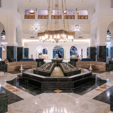 Grand hall luxueux avec fontaine centrale et lustres orientaux à l'hôtel Djerba Golf Resort & Spa.