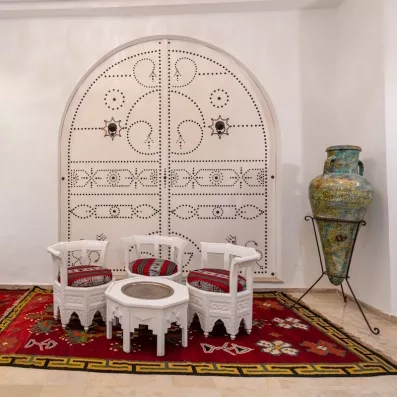 Salon traditionnel tunisien avec porte cloutée typique et jarre décorative à l'hôtel Djerba Golf.