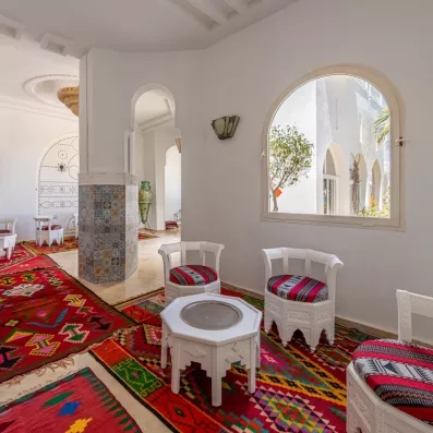 Salon traditionnel tunisien avec tapis colorés et architecture typique à l'hôtel Djerba Golf Resort & Spa.