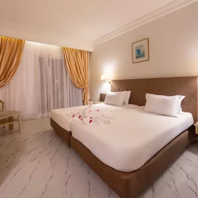 Chambre double élégante à l'hôtel Djerba Golf avec cygne en serviette et décoration romantique en Tunisie.