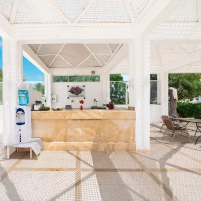 Granada Bar extérieur en pierre à l'hôtel Djerba Golf avec distributeur d'eau et toit en treillis.