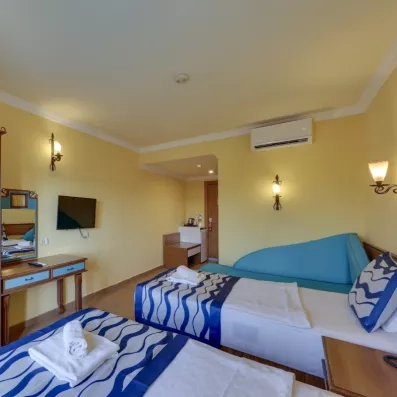 chambre club room avec deux lits simples et une télévision