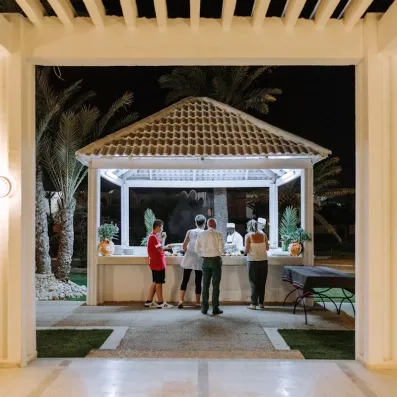 Kiosque de cuisine extérieure en soirée pour un dîner convivial sous les palmiers à Djerba Golf.