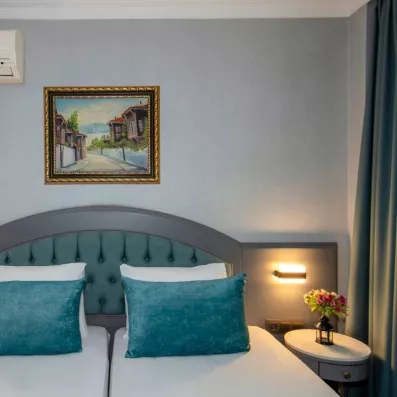 Vue de la chambre avec deux lits simples et tables de chevet