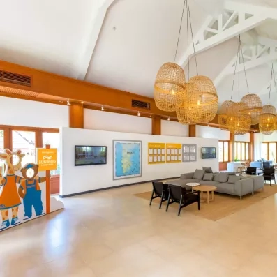 Hall de réception lumineux avec de hautes structures en bois, et des œuvres d'art colorées.