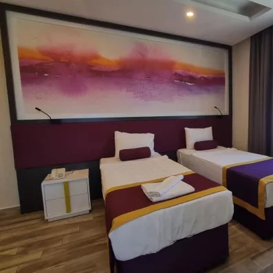 chambre avec deux lits simples et table de chevet