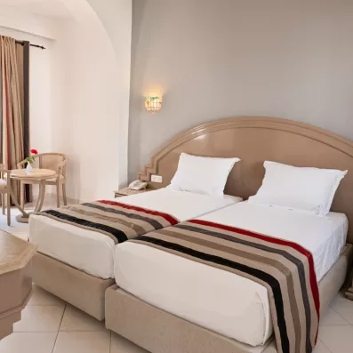 Chambre double élégante avec lits jumeaux et tête de lit sculptée au One Resort Aqua Park Monastir.