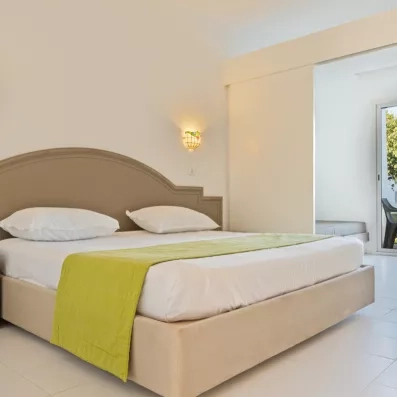 Lit double confortable avec chemin de lit vert et terrasse privée au One Resort Aqua Park Monastir.