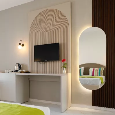 Bureau moderne avec télévision et miroir ovale rétroéclairé dans une chambre du One Resort Aqua Park Monastir.