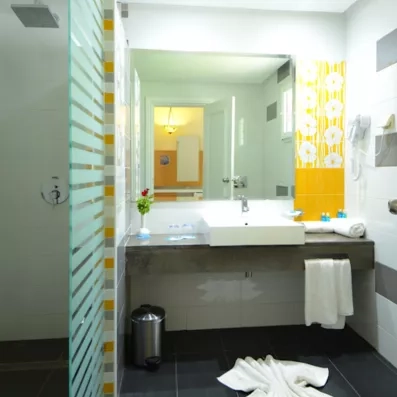 Salle de bain lumineuse avec douche à l'italienne et carrelage floral au One Resort Aqua Park Monastir.