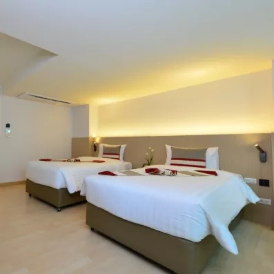 Une chambre spacieuse avec deux lits doubles avec des décorations de bienvenue.