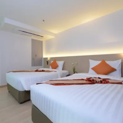 Une chambre avec deux lits doubles, avec des décorations de bienvenue.