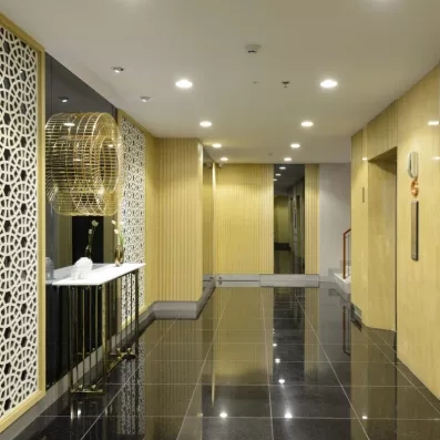 Un couloir moderne, bordé de murs aux tons dorés et d'un comptoir.
