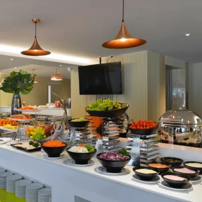 Un buffet varié présentant une sélection de salades, de fruits frais et de plats froids.