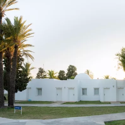 Architecture traditionnelle des bungalows blancs entourés de jardins verdoyants au One Resort Aqua Park à Monastir.