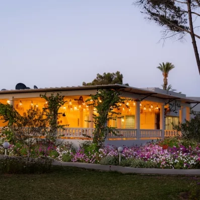 Restaurant extérieur Sofra illuminé le soir avec jardins fleuris au sein du One Resort Aqua Park Monastir.