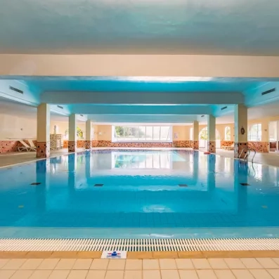 Grande piscine intérieure chauffée aux eaux turquoise pour se détendre au Djerba Resort en Tunisie.