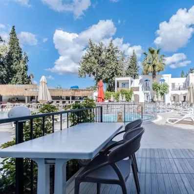 table face à la piscine et les transats