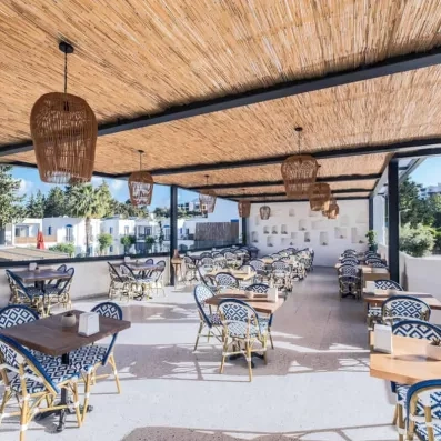 terrasse avec tables en bois et chaises sous une pergola en bambou