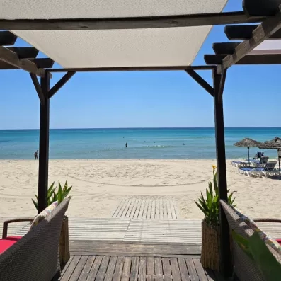 Terrasse ombragée offrant une vue directe sur la plage et la mer