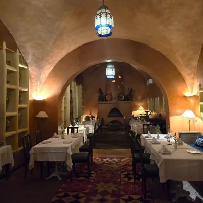 Restaurant chaleureux sous voûtes en terre cuite, éclairé par lanternes suspendues