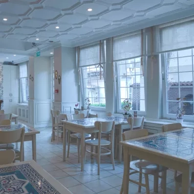 salle de restaurant avec tables et chaises et de grandes fenêtres